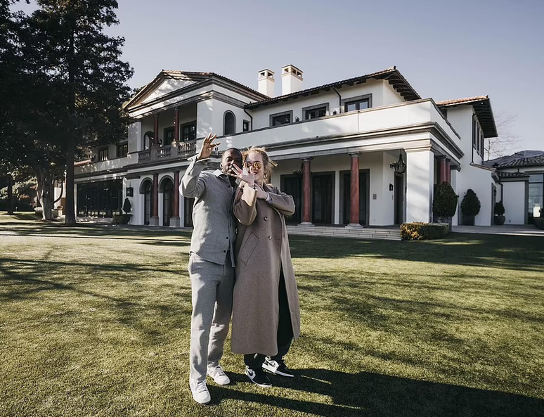 Adele dan suaminya berpose dengan latar belakang mansion