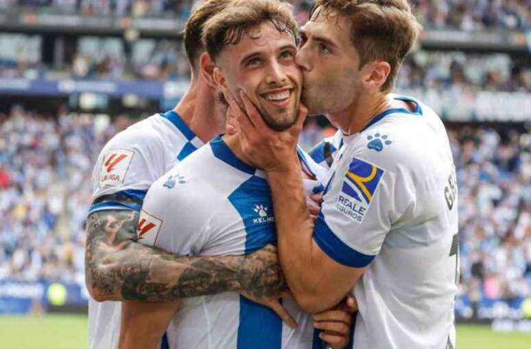 Puado recebe um beijo na comemoração de seu segundo gol sobre o Oviedo. Seus tentos garantiram  a volta do time à Primeira Divisão