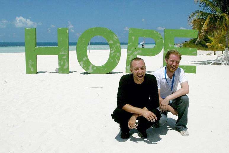 Chris Martin com o guitarrista John Buckland apoiando a campanha do Comércio Justo em uma praia de Cancún, México (2003).