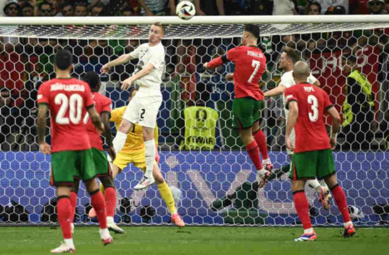 Cristiano Ronaldo em disputa de bola com jogador da Eslovênia –