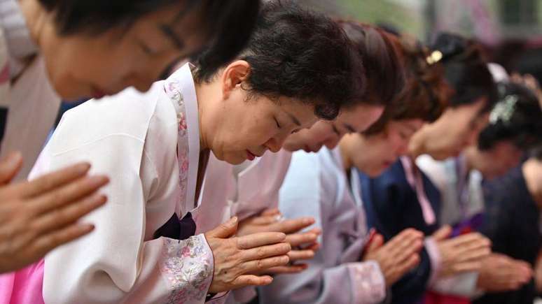 Budistas rezando durante uma cerimônia no templo Jogyesa em Seul, em 15 de maio de 2024
