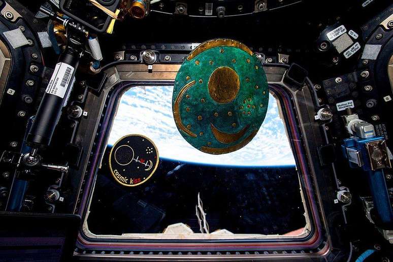 O astronauta Matthias Maurer, da Agência Espacial Europeia, colocou sua insígnia da missão 'Beijo Cósmico' e uma réplica do disco de Nebra para flutuar na cúpula de sete janelas da Estação Espacial Internacional em 2022