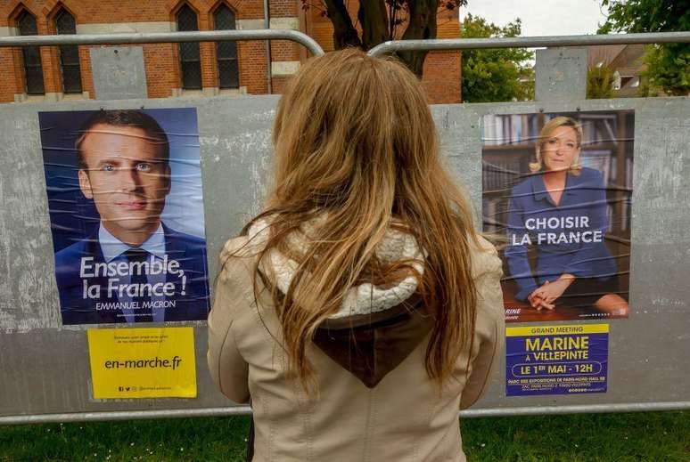 O presidente francês Emmanuel Macron e Marine Le Pen em cartazes de campanha