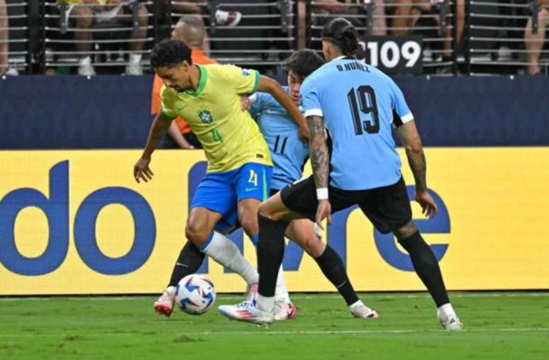 Marquinhos &eacute; pressionado por Pellistri e&nbsp; Darwin N&uacute;&ntilde;ez. Mas consegue sair com a bola. Assim, evita o perigo para o Brasil.