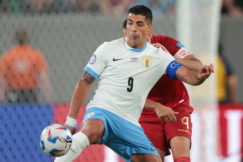 O atacante uruguaio Luis Suarez (9) joga a bola na frente do zagueiro boliviano Luis Haquin (4) durante o segundo tempo da partida da Copa América no MetLife Stadium.