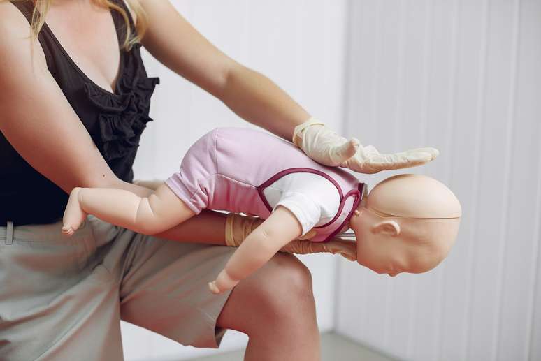 Para desobstruir a respiração do bebê, é preciso aplicar pressão nas costas e depois no tórax até o objeto estranho ser expelido