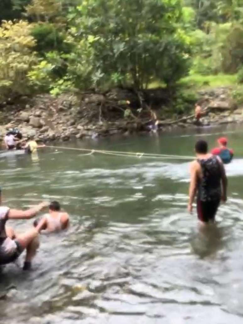 Imagem tirada de um dos vídeos gravados por Michell Stella durante a travessia de Darién, mostrando as pessoas usando cordas para atravessar o rio