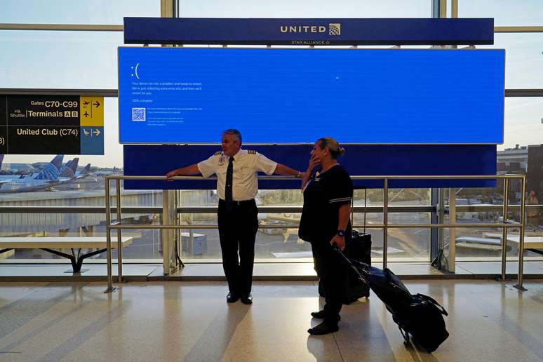 Funcionários da United Airlines aguardando o retorno do sistema Windows em aeroporto em de Newark, Nova Jersey (EUA)