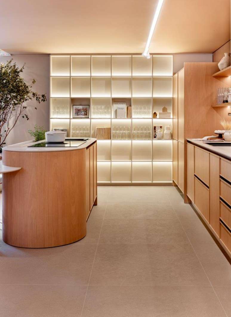 Una isla con un huerto incorporado es lo más destacado de la cocina tipo loft.  Proyecto Josiane Pavenato.  En la foto hay una cocina con estantes especializados e iluminación incorporada.