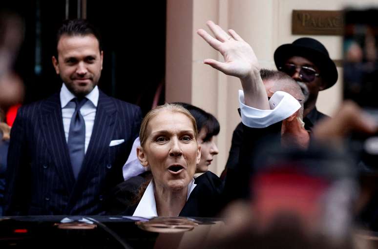 23 de julho de 2024 - A cantora Celine Dion acena para os fãs do lado de fora de seu hotel antes das Olimpíadas de Paris 2024.