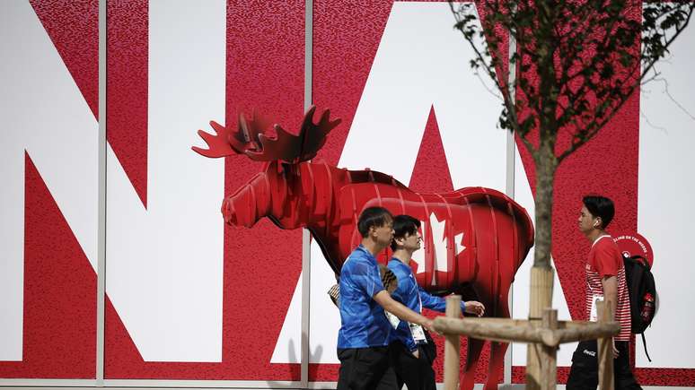Atletas caminham em frente ao pr&eacute;dio do Canad&aacute; na Vila Ol&iacute;mpica , antes das Olimp&iacute;adas de Paris 2024 