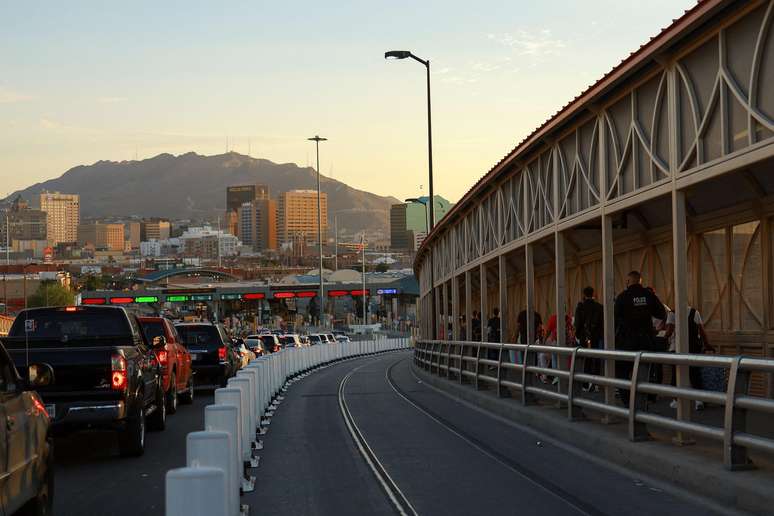 Migrantes em busca de asilo nos EUA caminham em direção à alfândega dos EUA na ponte da fronteira internacional Paso del Norte