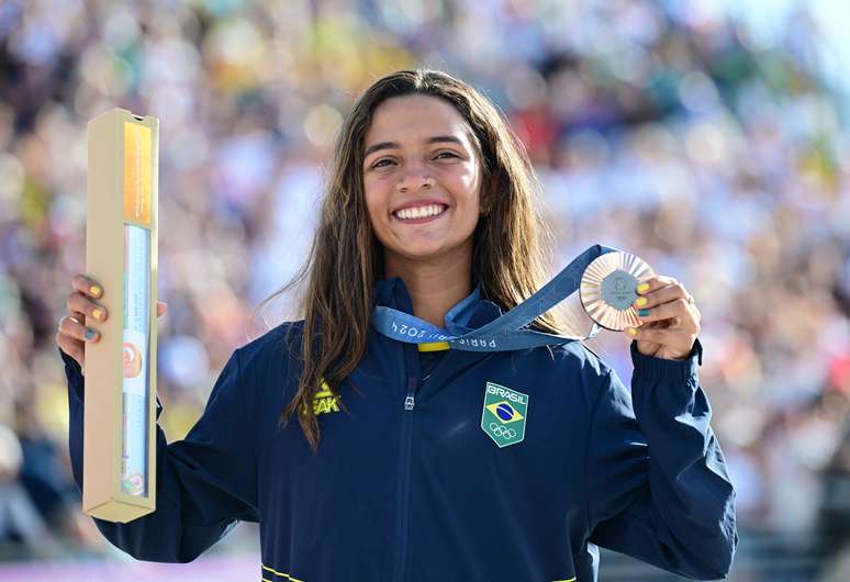 A medalhista de bronze, Rayssa Leal, do Brasil, posa com sua medalha enquanto comemora no pódio.