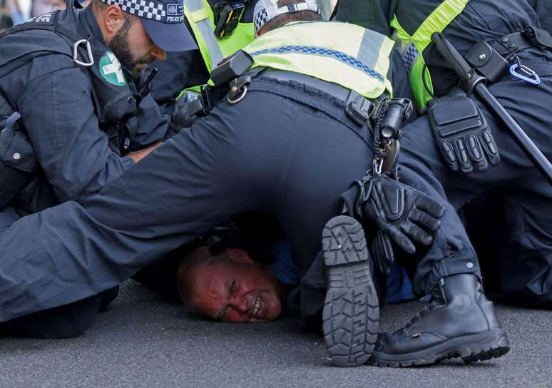 Policiais detêm manifestante durante protesto contra imigração ilegal nas imediações de Downing Street, residência oficial e escritório do primeiro-ministro britânico