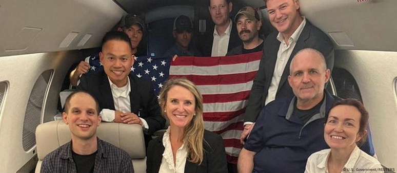 O ex-membro da Marinha Americana Paul Whelan (camisa polo azul marinho) e os jornalistas Evan Gershkovich (sentado à esquerda) e Alsu Kurmasheva (sentada à direita) a bordo de avião do governo americano