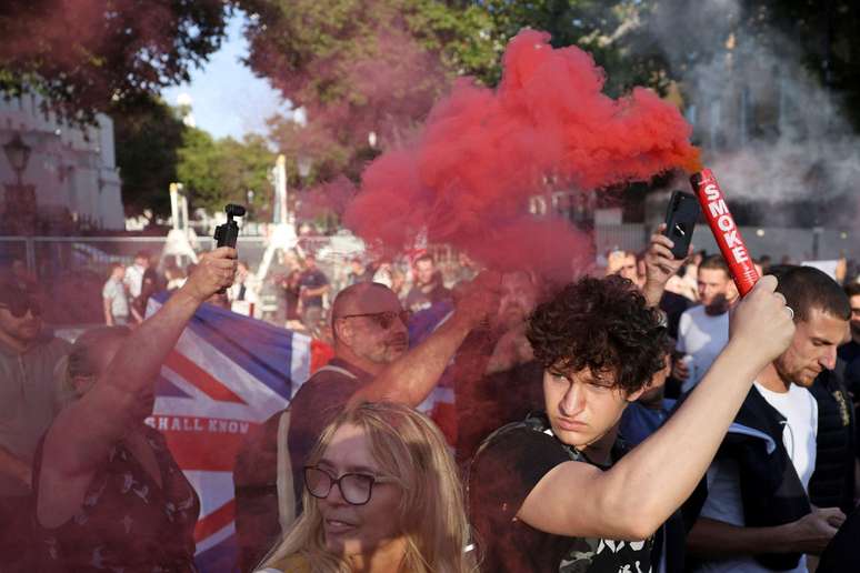 Manifestante segura um sinalizador durante um protesto em Londres