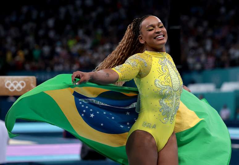 Rebeca Andrade com a bandeira do Brasil após conquista da medalha de prata