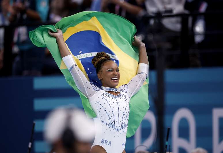 Rebeca Andrade comemora com a bandeira do Brasil após ganhar a prata na ginástica