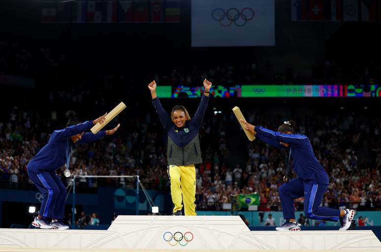 A medalhista de ouro Rebeca Andrade no pódio sendo reverenciada 