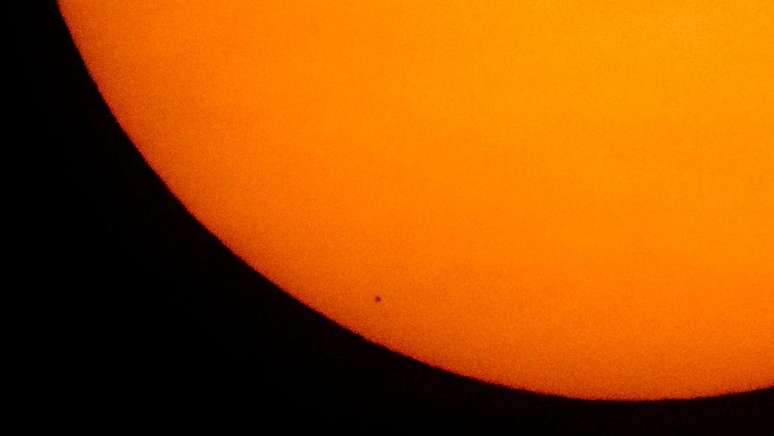 Mercúrio visto como um pequeno ponto na área inferior esquerda do Sol, em um raro fenômeno chamado Trânsito de Mercúrio