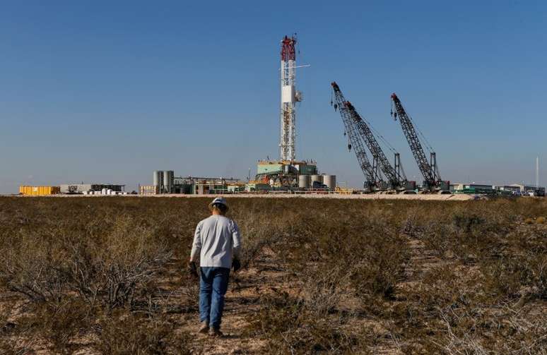 Trabalhador caminha em direção a uma plataforma de perfuração depois de colocar equipamento de monitoramento de solo, em Loving County, no Texas, EUA
22/11/2019
REUTERS/Angus Mordant/File Photo