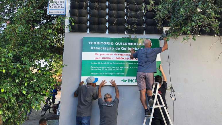 Moradores instalam placa do Quilombo Kédi na fachada da associação. Prédio fica no local de antigo terreiro e chegou a abrigar templo católico