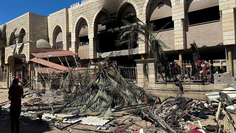 Palestinos observam os danos no local de um ataque israelense a uma escola que abrigava pessoas deslocadas, em meio ao conflito entre Israel e o Hamas, na Cidade de Gaza, em 10 de agosto de 2024