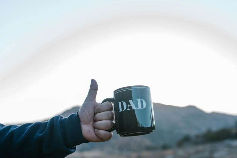 Você pode mandar imprimir fotos, imagens ou textos personalizados na caneca do seu pai, e incluir algo dentro.