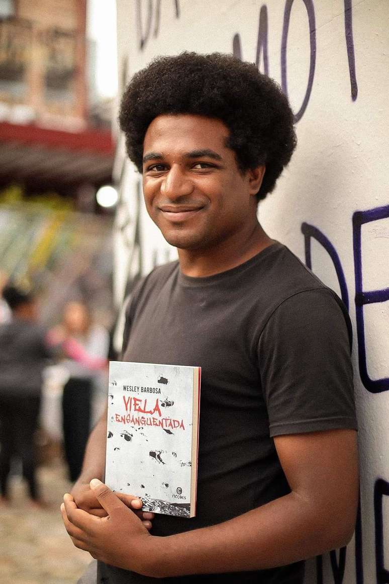 O escritor Wesley Barbosa com a versão brasileira do romance traduzido para o francês.