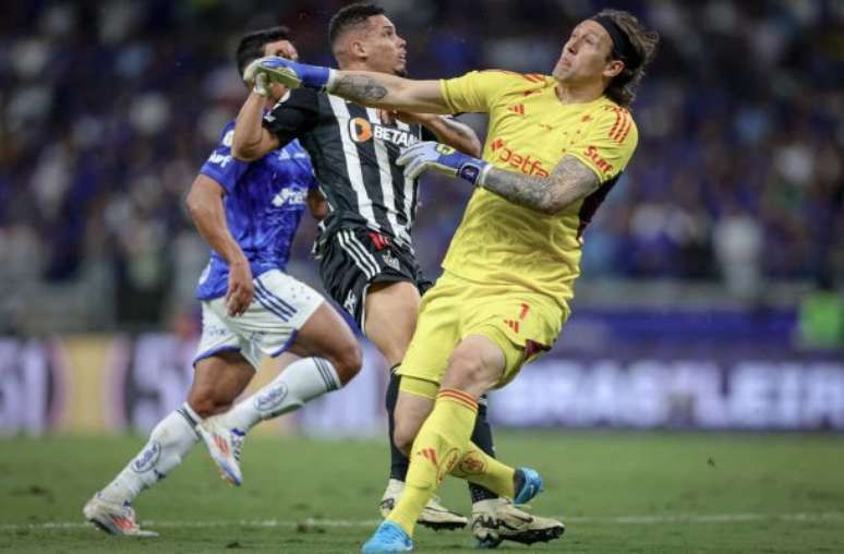 Cassio, goleiro do Cruzeiro, sai mas não evita o toque por cima de Paulinho, atacante do Atlético. Contudo, esta bola será salva por William antes de chegar ao gol.