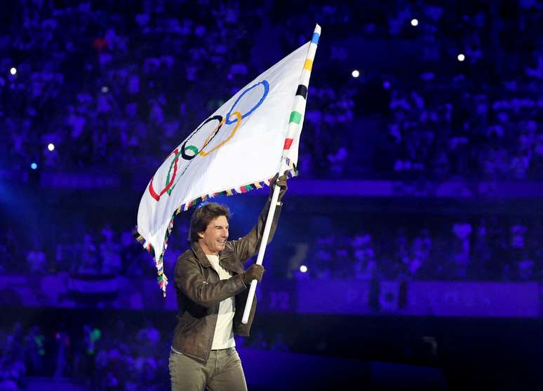 Tom Cruise carregando a bandeira olímpica 