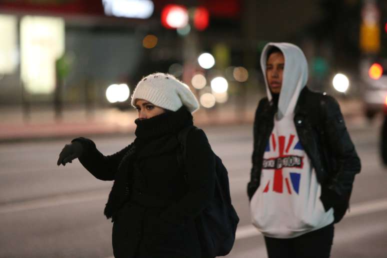 Pedestres caminham na Avenida Paulista, em São Paulo em dia frio