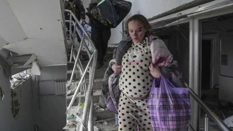 Grávida e ferida desce as escadas da maternidade danificada por bombardeios na Ucrânia – Foto: Associated Press/Reprodução