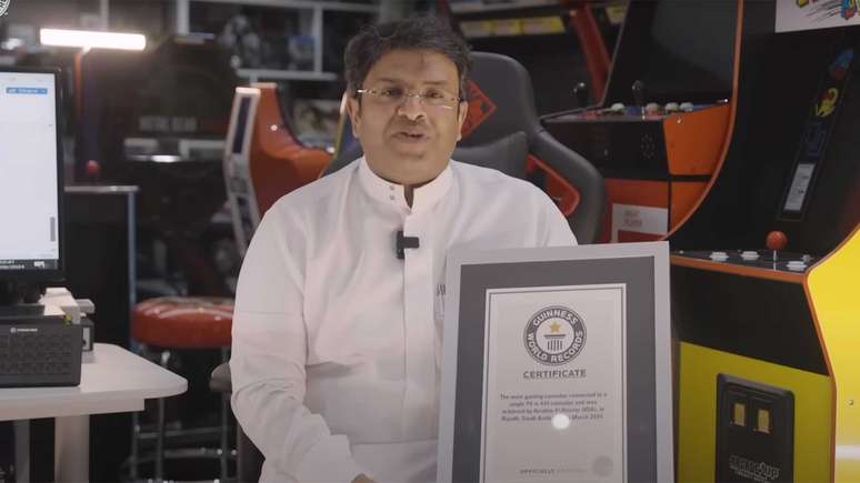 Ibrahim Al-Nasser com a placa obtida por conectar 444 videogames na mesma TV de forma simultânea