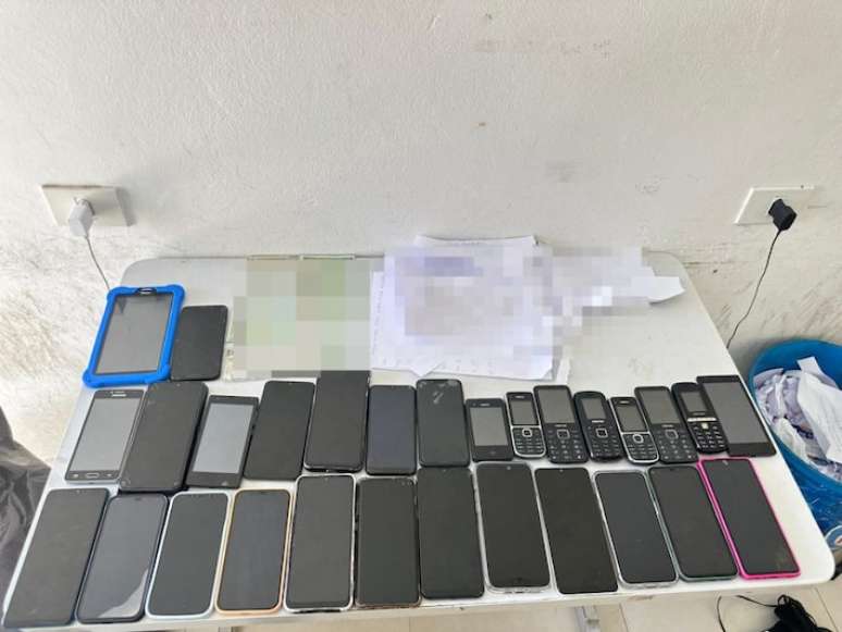 Celulares e chips que eram usados pelos criminosos foram apreendidos pela polícia no local onde eram aplicados os golpes.