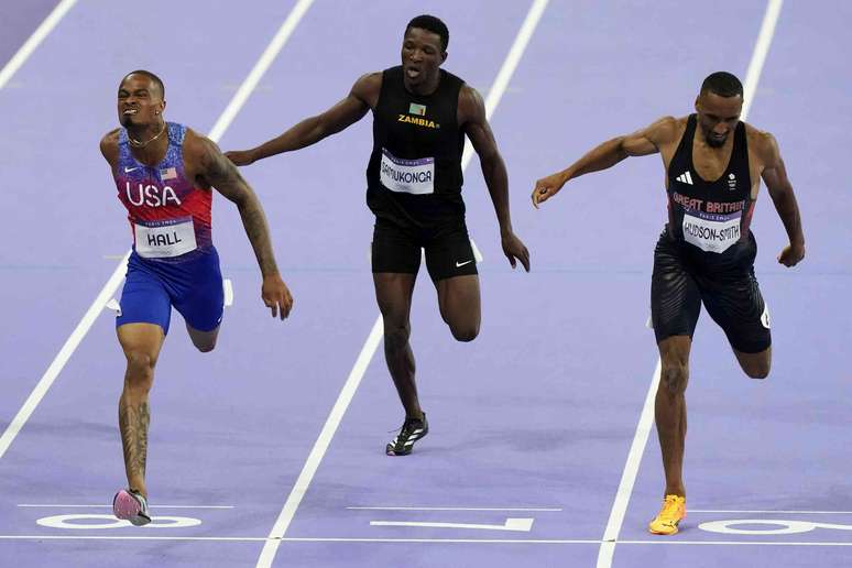 Tr&ecirc;s homens, parecendo cansados, correndo em trilhos.