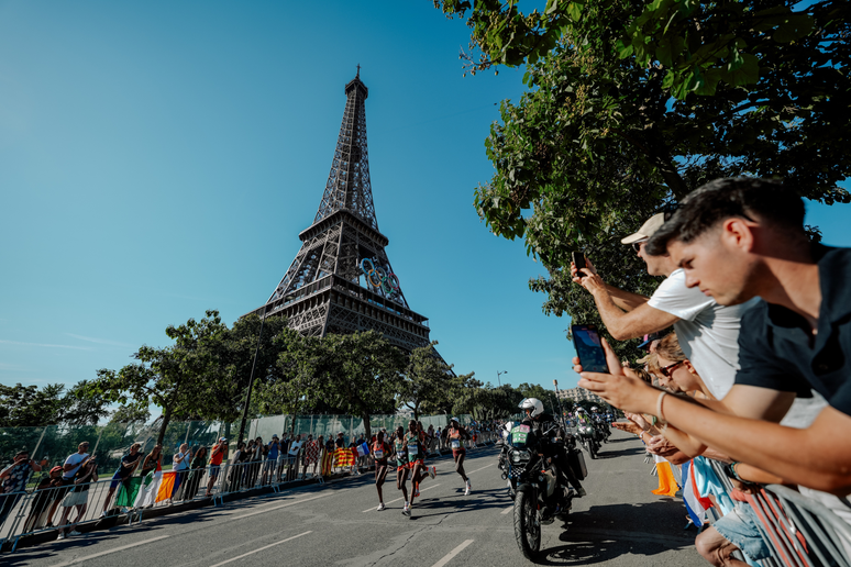 Torre eiffel ao fundo de uma maratona nos Jogos Olímpicos