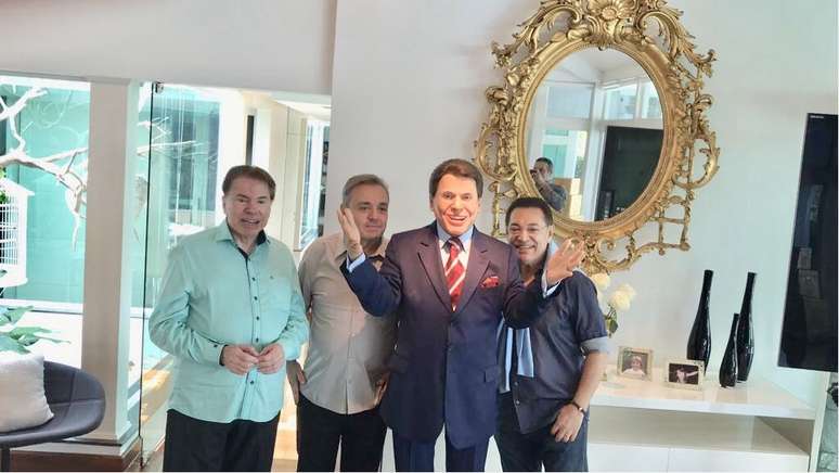 Silvio Santos posa com Jassa, Gugu e uma estátua do apresentador