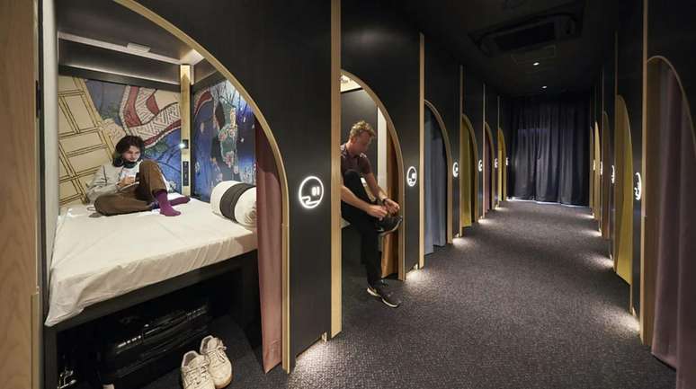 Duas pessoas em camas dentro de c&aacute;psulas