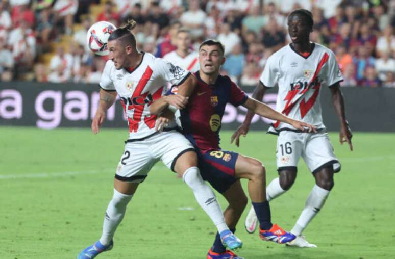 Jogadores de Rayo Vallecano e Barcelona em disputa de bola no Espanhol –