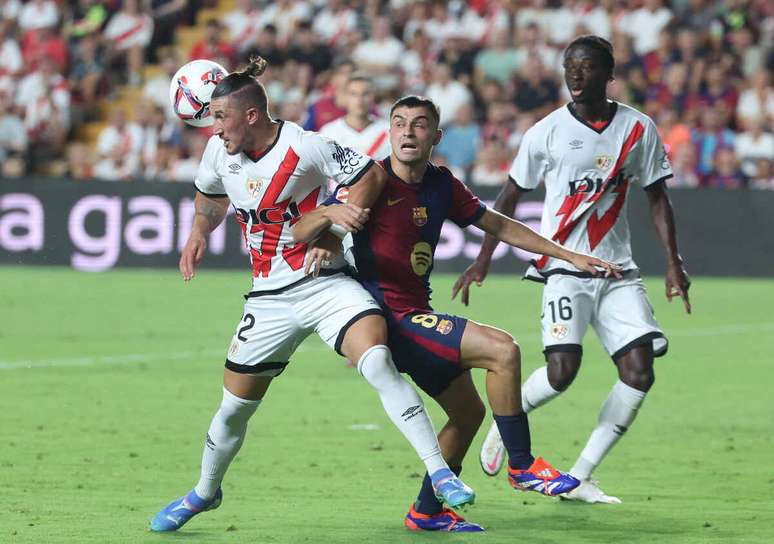 Jogadores de Rayo Vallecano e Barcelona em disputa de bola no Espanhol –