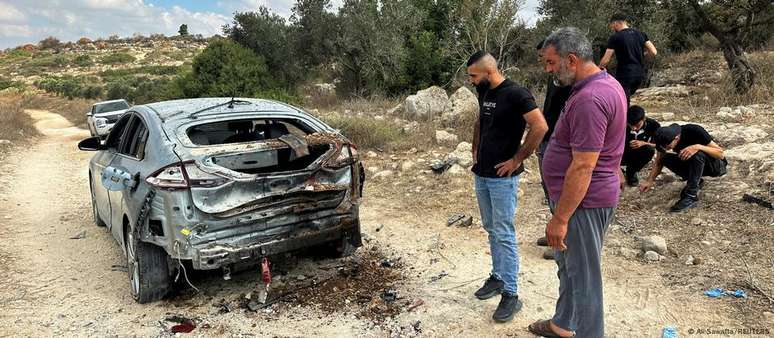 Palestinos observam carro incendiado durante operação israelense na Cisjordânia; tensão na região aumentou com a guerra Israel-Hamas