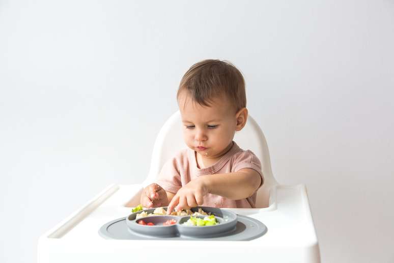 Shutterstock, Inc. Cute,Little,Baby,Infant,Eating,Complementary,Foods,On,White,Background.