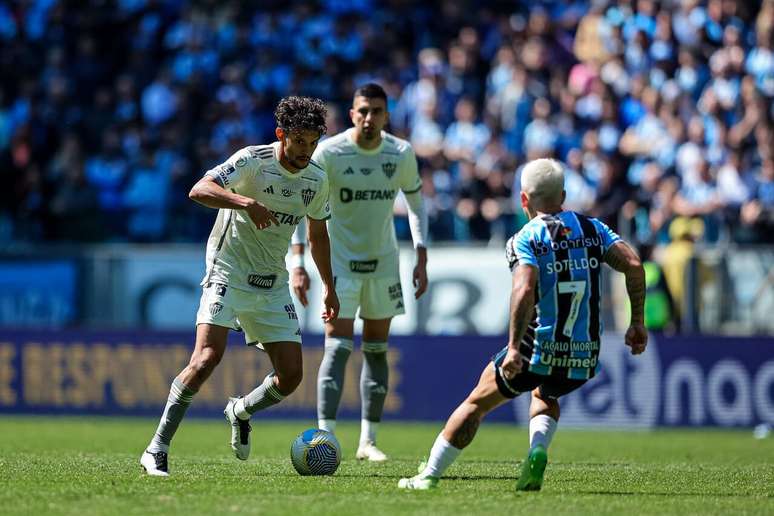 Soteldo faz a marcação em cima de Scarpa durante o duelo entre Grêmio e Atlético, na Arena gremista.