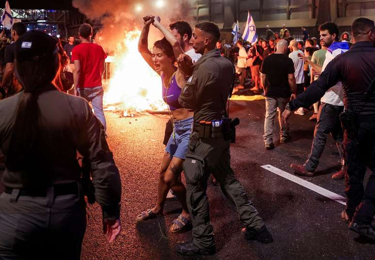 Protestos de domingo foram em grande parte pac&iacute;ficos, mas momentos de maior tens&atilde;o foram registrados em Tel Aviv ap&oacute;s manifestantes colocarem fogo em barricadas