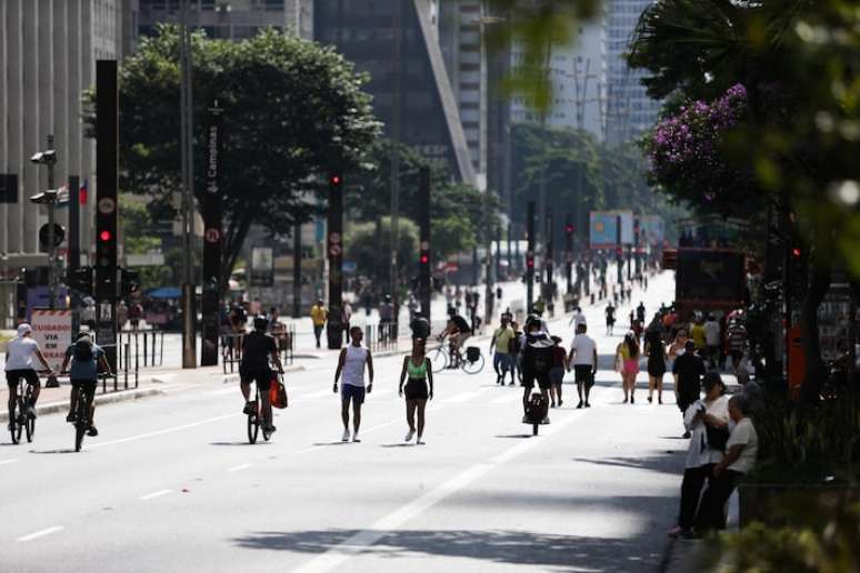 Pessoas caminhando pela Avenida Paulista durante forte dia de calor.