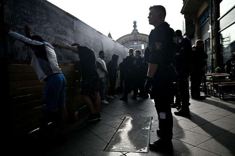 Policiais revistam suspeitos do lado de fora da estação de Frankfurt em setembro de 2023