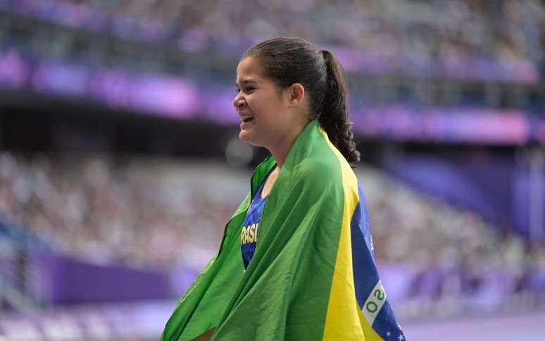 Verônica celebra a volta ao pódio com a bandeira brasileira