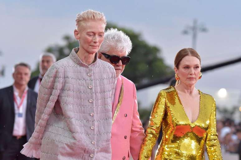 As atrizes Tilda Swinton e Juliane Moore caminham com o diretor Pedro Almodóvar na première do filme 'The Room Next Door' em Veneza