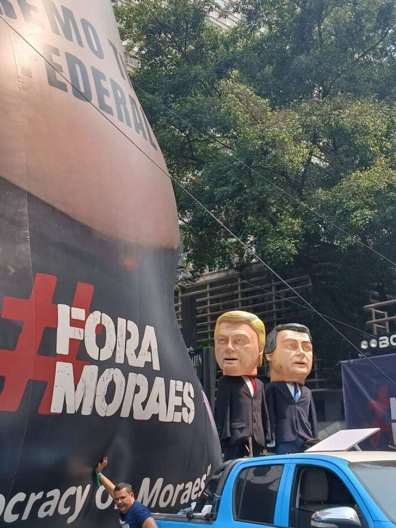 Bonecos de Trump e Bolsonaro em frente a um balão inflável que diz 'Supremo Tirano Federal', em crítica ao STF, na mobilização para o ato com Bolsonaro na Avenida Paulista